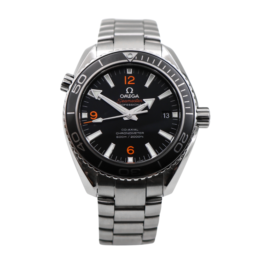 An Omega Seamaster Planet Ocean Co-Axial Chronometer watch with a stainless steel case and bracelet, featuring a black dial with bold orange numerals, luminescent hour markers, and hands, displayed on a clear stand.